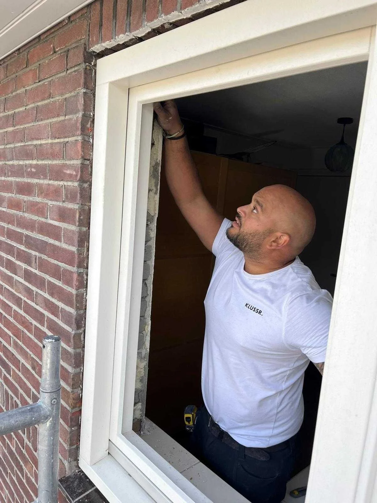 Vakman van KLUSSR. plaatst een nieuw kozijn